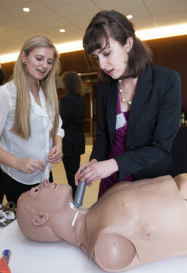 Engineering students Jordan Kreger, left, and and Sondra Rahmeh use a medical mannequin to test the CricSpike device's ability to create a new airway in an injured soldier's neck. Photo by John Bidlack/Homewood Photography.